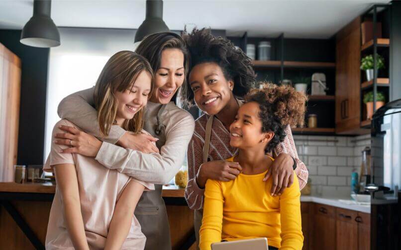 A joyful group of four people in a modern kitchen.