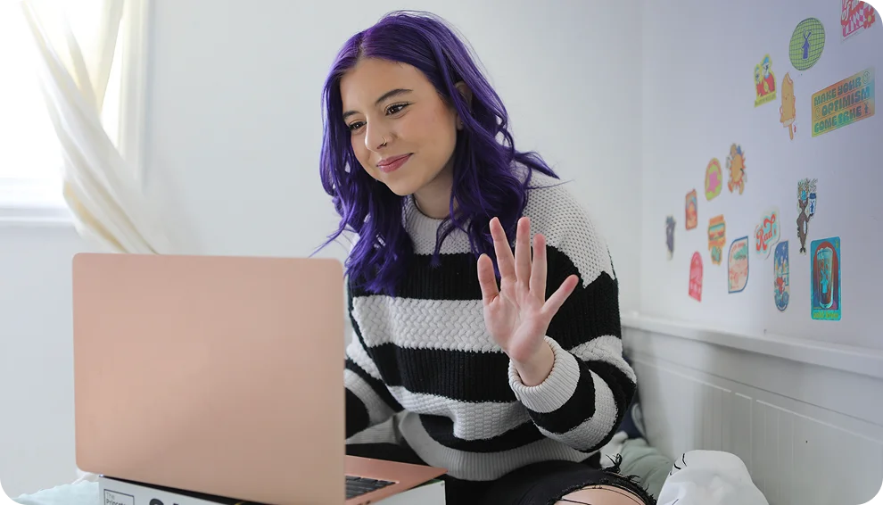 Student attending to an online class wearing a stripped sweater