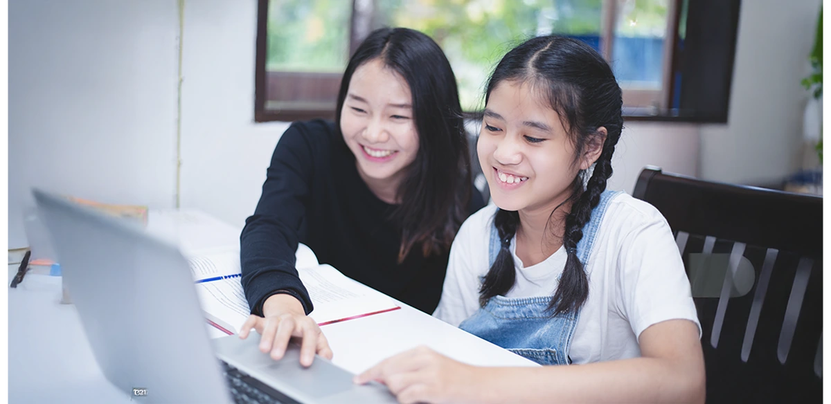 girls smiling and looking the computer